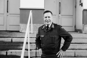 Kenttäpiispa Pekka Asikainen hymyilee päääesikunnan portailla. 